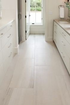 a long white bathroom with two sinks and mirrors