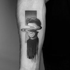 a black and white photo of a man's arm with a saturn tattoo on it