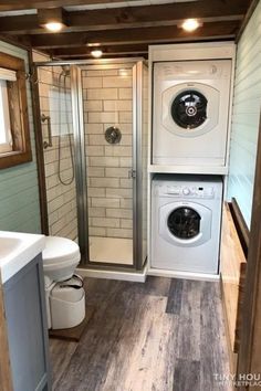a washer and dryer in a small bathroom with wood flooring on the walls