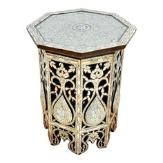 an intricately designed side table with glass top