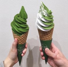 two ice cream cones with green and white toppings, one being held up to the camera