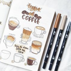 an open notebook with coffee drawings and pencils next to it on top of a table