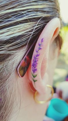 a woman with purple flowers behind her ear