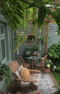 an outdoor patio with chairs, table and potted plants