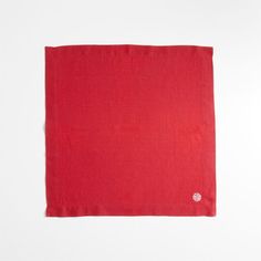 the red scarf is folded on top of a white surface