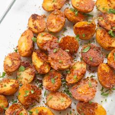 cooked potatoes with parsley and seasoning on a baking sheet, ready to be eaten