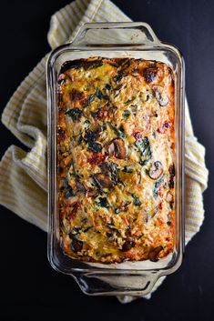 a casserole in a glass dish with mushrooms and spinach toppings on top