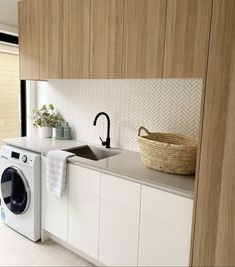 a washer and dryer in a small room with wood paneling on the walls