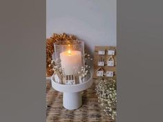 a white candle sitting on top of a wicker table
