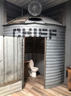 an outhouse with the door open and a toilet in it