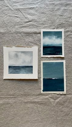 three paintings are displayed on a sheet of paper, one is blue and the other is white