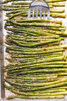 roasted asparagus on a baking sheet with a spatula in the bottom right corner