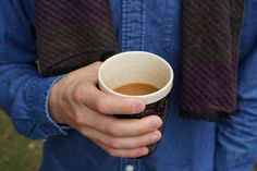 a person holding a coffee cup in their hands
