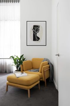 a living room with a yellow chair and ottoman