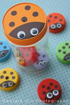 a jar filled with lots of different colored buttons on top of a blue tablecloth