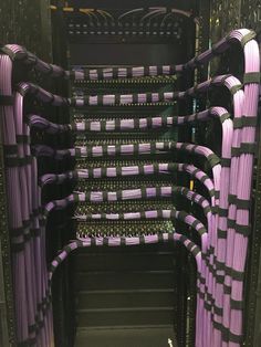 the inside of a server room filled with lots of purple wires