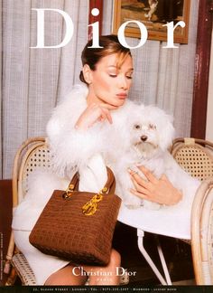 a woman sitting at a table with a dog in her lap and the cover of a magazine