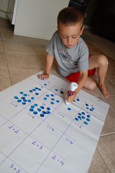 a little boy sitting on the floor playing with numbers