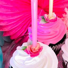 cupcakes with pink frosting and two lit candles