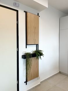a wall mounted planter on the side of a white wall next to a door