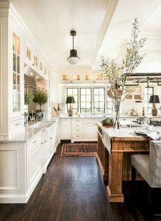 a large kitchen with white cabinets and wood floors