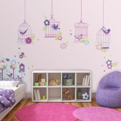 a child's bedroom decorated in pink and purple with birdcages hanging from the ceiling