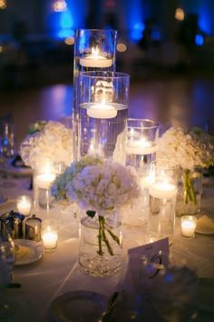 a table topped with lots of white flowers and candles