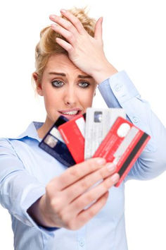 a woman holding several credit cards in front of her face and looking at the camera