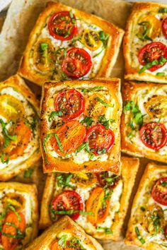many square pieces of bread with tomatoes and cheese on them are arranged in a pattern