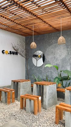 the inside of a restaurant with wooden benches and planters on the wall, along with stone flooring
