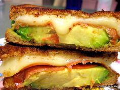 two sandwiches are stacked on top of each other with cheese and vegetables in between them