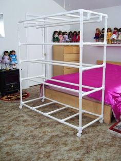 a white metal bunk bed frame with pink sheets and pillows on the bottom, in a bedroom