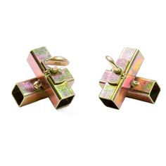 pair of gold tone cufflinks with pink and green holographic print on them