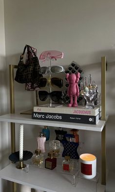 a shelf with many items on it and a pink teddy bear sitting next to them