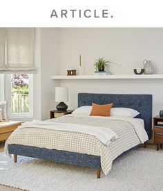 a king sized bed with blue upholstered headboard and foot board in a bedroom