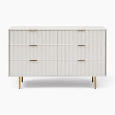 a white dresser with four drawers and two gold handles on the top, against a white background