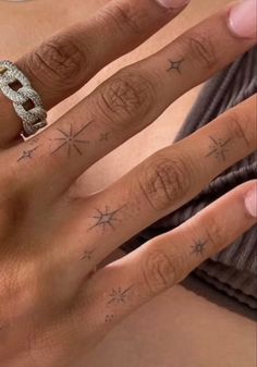 a woman's hand with stars on it and a diamond ring in the middle