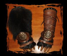 a pair of leather gloves with fur on the top and one glove has metal decorations
