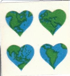 four heart shaped stickers with the earth on them in blue and green, set against a white background