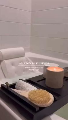 a bathtub with a candle, soap and brush sitting on the tray next to it
