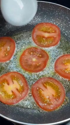 tomatoes and butter cooking in a frying pan on the stove top with some oil
