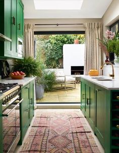 a kitchen with green cabinets and an area rug