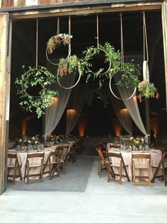 an open barn door with tables and chairs set up for a formal function in front of it