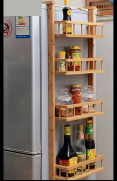 a wooden spice rack with spices and condiments on it next to a refrigerator