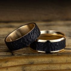 two black and gold wedding bands on top of each other