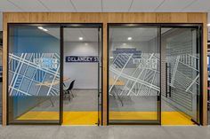 an office building with glass doors and yellow trimmings on the outside wall,