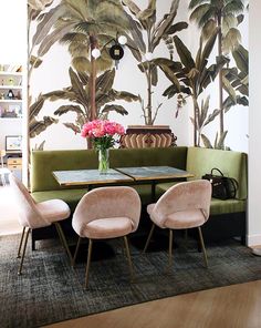 an instagram page with a green couch and table in front of a palm tree mural
