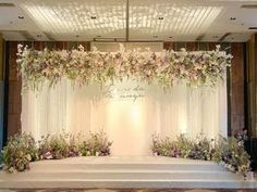 a wedding stage decorated with flowers and greenery