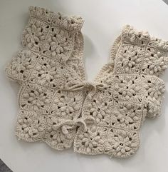 three crocheted pieces of cloth sitting on top of a white table next to each other