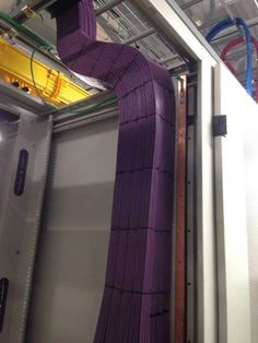 the inside of a large machine with purple fabric on it's side and metal pipes